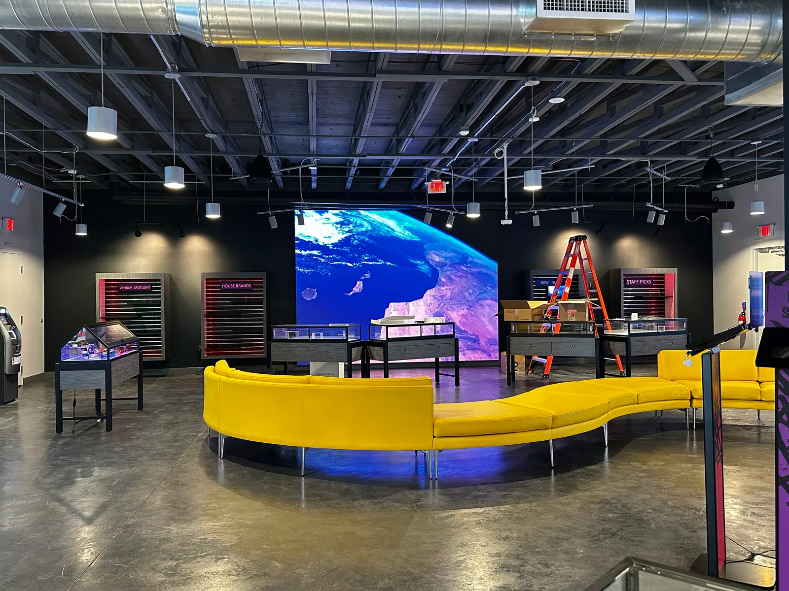 Video wall showing Earth from space in a showroom with a yellow curved bench