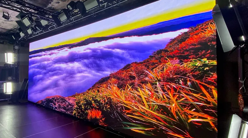Large video wall showing a mountain landscape above clouds in a studio